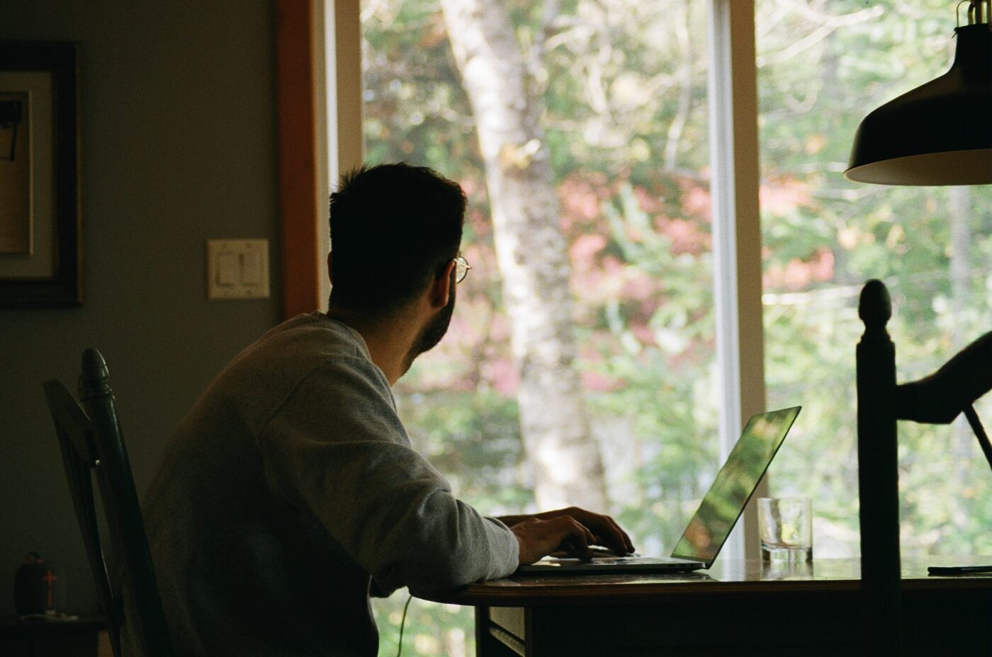 man at desk looking out window