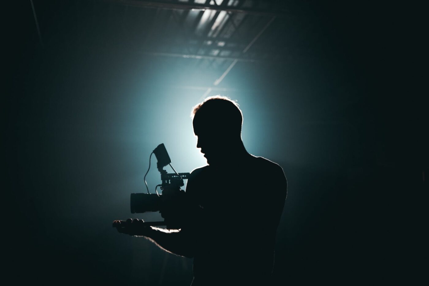 a silhouette of man holding a camera