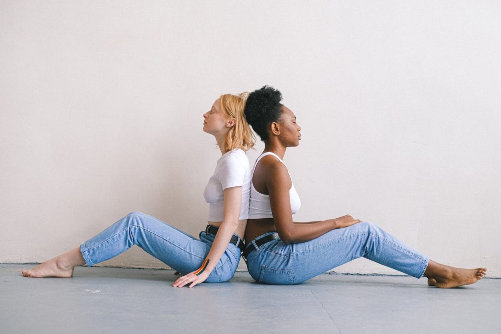 two women sitting back to back