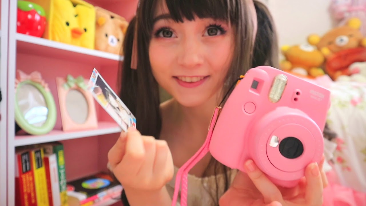 Venus Angelic holding a pink camera